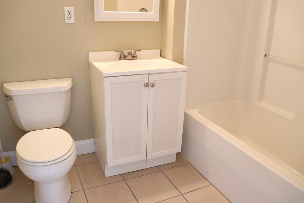 Clean full bathroom with white vanity and tub-shower combo at 111 Lawrence Street #606