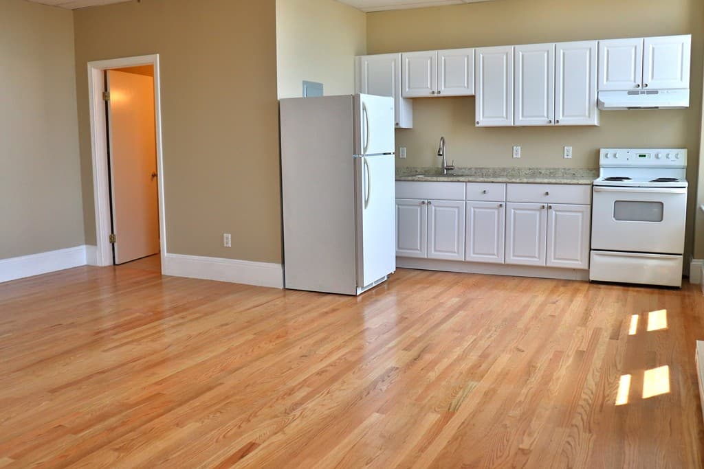 Functional kitchen with white shaker cabinets and granite-style counters at 111 Lawrence Street #606